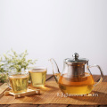 Teiera in vetro da cucina con foglie di tè e caffè